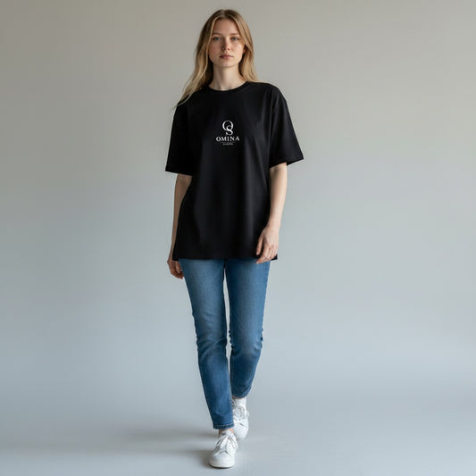 Omina black heavyweight cotton boxy t-shirt with raw edge detailing on a woman wearing blue jeans.