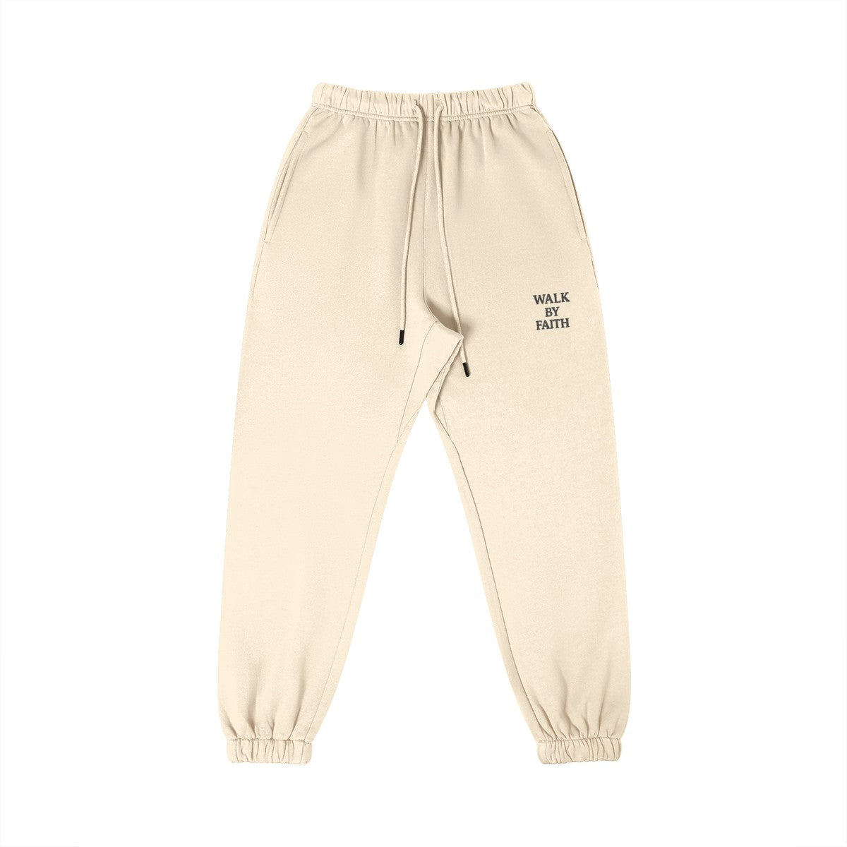 Omina Studio cream heavyweight cotton sweatpants with tapered fit and "Walk By Faith" embroidered detail.