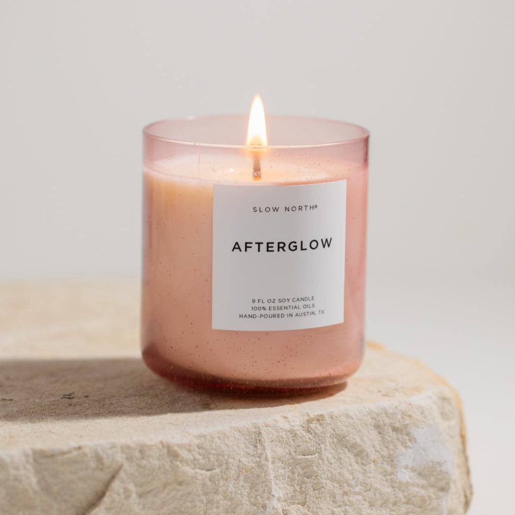 Slow North Afterglow Spa Collection candle with softly glowing flame and elegant container, perfect for relaxing spa ambiance.
