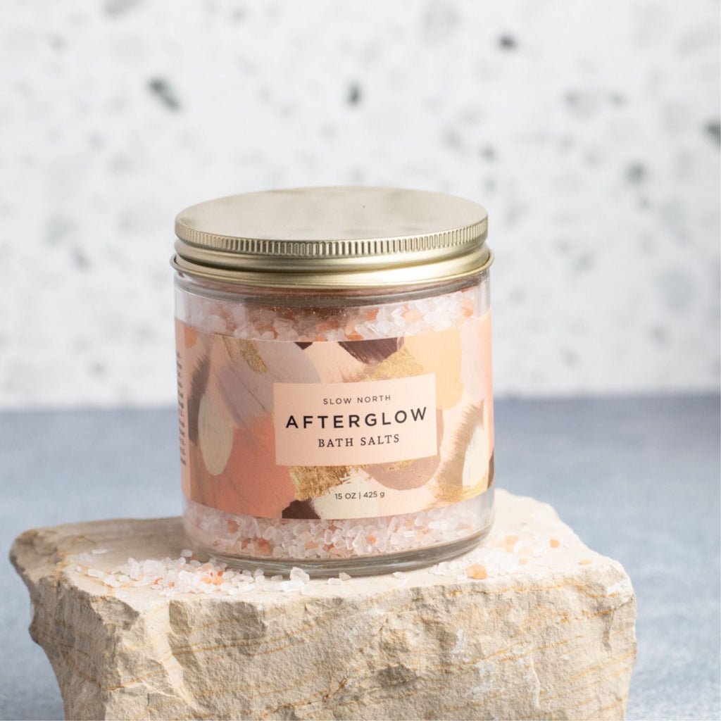Slow North Afterglow Bath Salts in a 15 oz jar, showing a clear glass jar filled with pink bath salts and a wooden scoop.