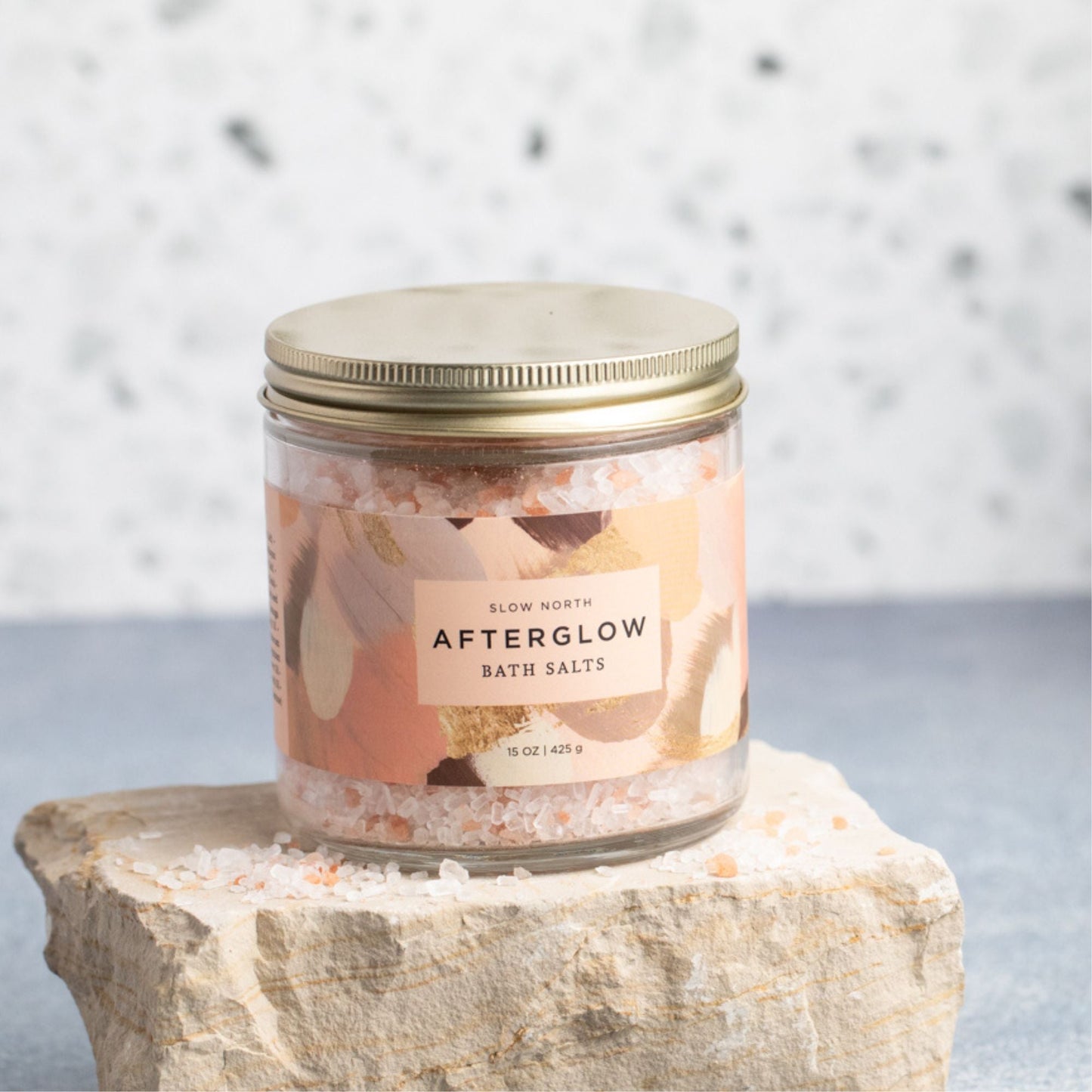 Slow North Afterglow Bath Salts in a 15 oz jar, showing a clear glass jar filled with pink bath salts and a wooden scoop.