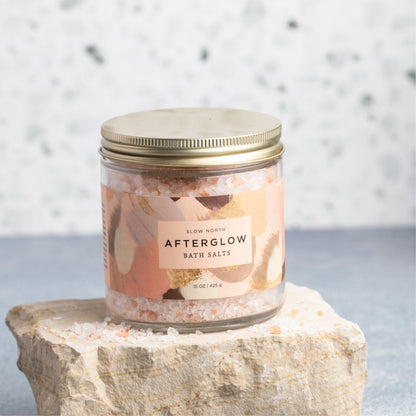 Slow North Afterglow Bath Salts in a 15 oz jar, showing a clear glass jar filled with pink bath salts and a wooden scoop.