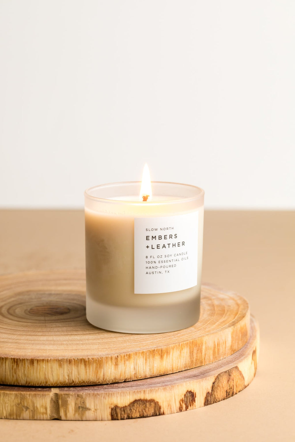 Frosted candle by Slow North featuring Embers + Leather scent with vetiver, cedar, and patchouli in a sleek glass holder.