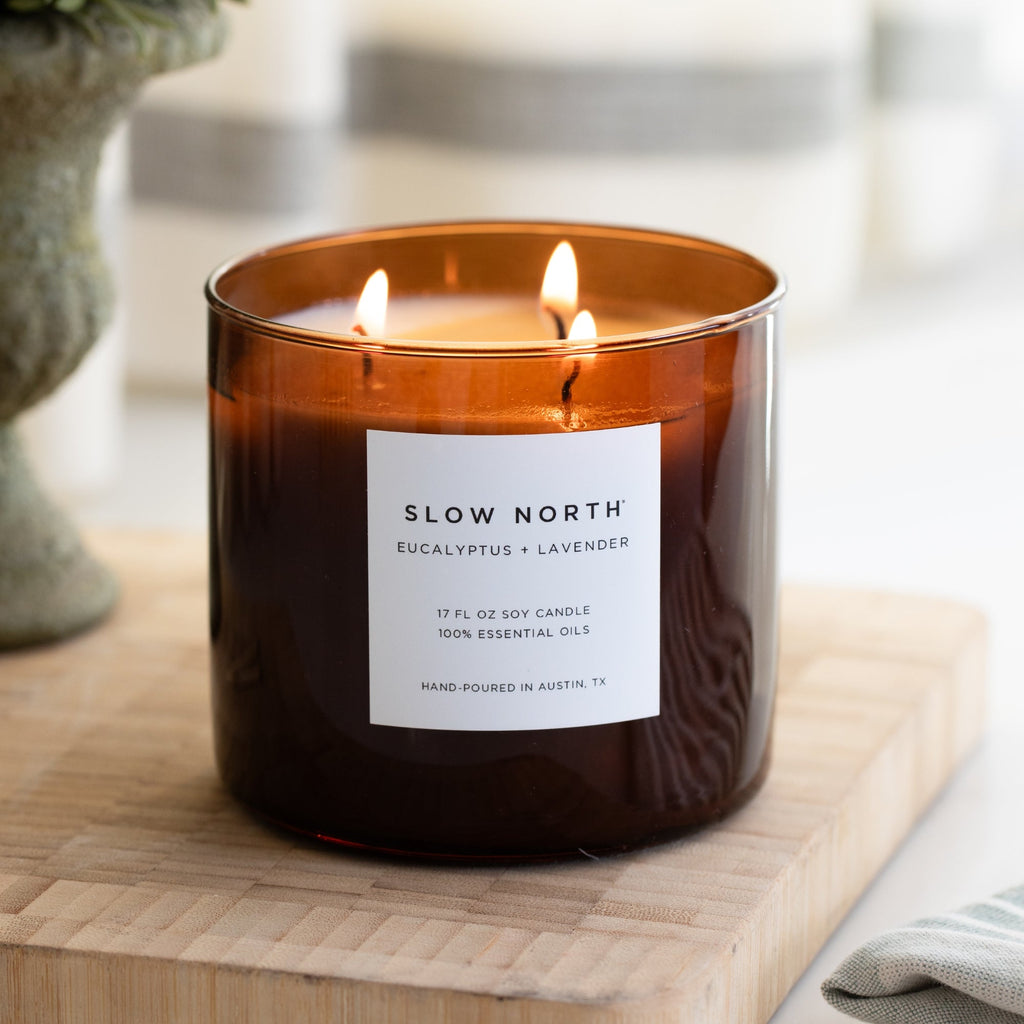 Slow North Signature 3-Wick Candle with eucalyptus and lavender scent, showing a elegant glass jar and three wicks inside.