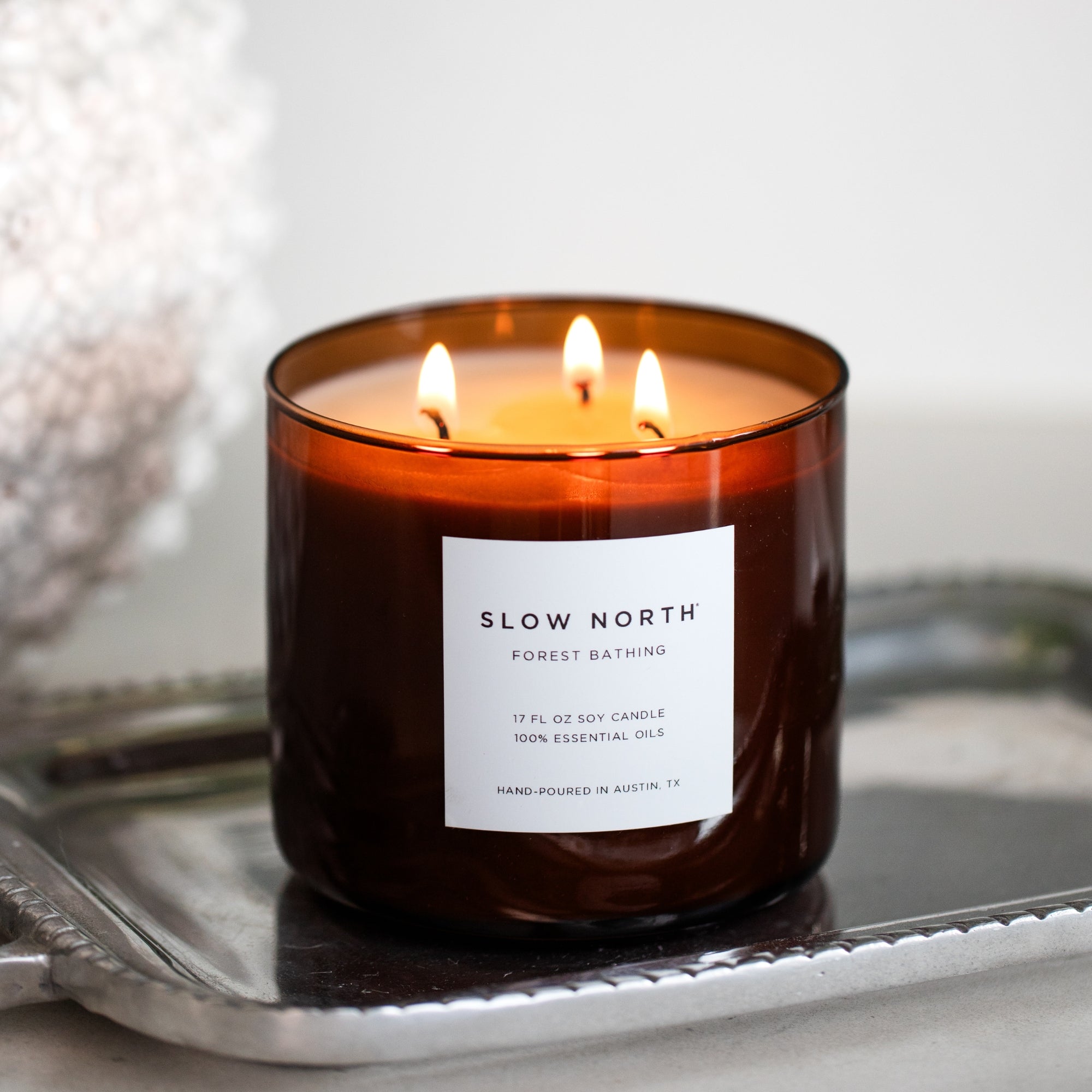 Slow North Forest Bathing Signature 3-Wick Candle with natural wood and green foliage design, ideal for creating a calming ambiance.