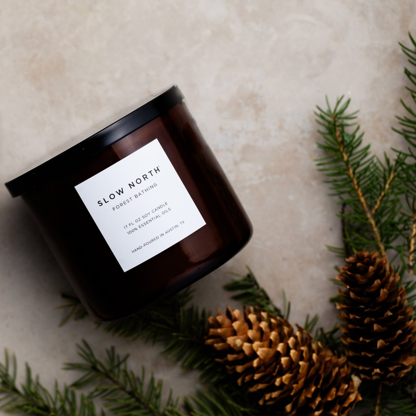 Slow North Forest Bathing Signature 3-Wick Candle with lush green foliage and wooden accents in a clear glass jar.
