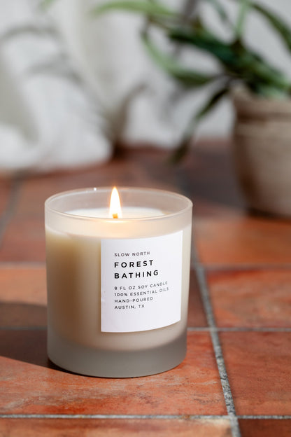 Frosted candle by Slow North featuring forest-inspired scents of fir, pine, and patchouli in a frosted glass container.