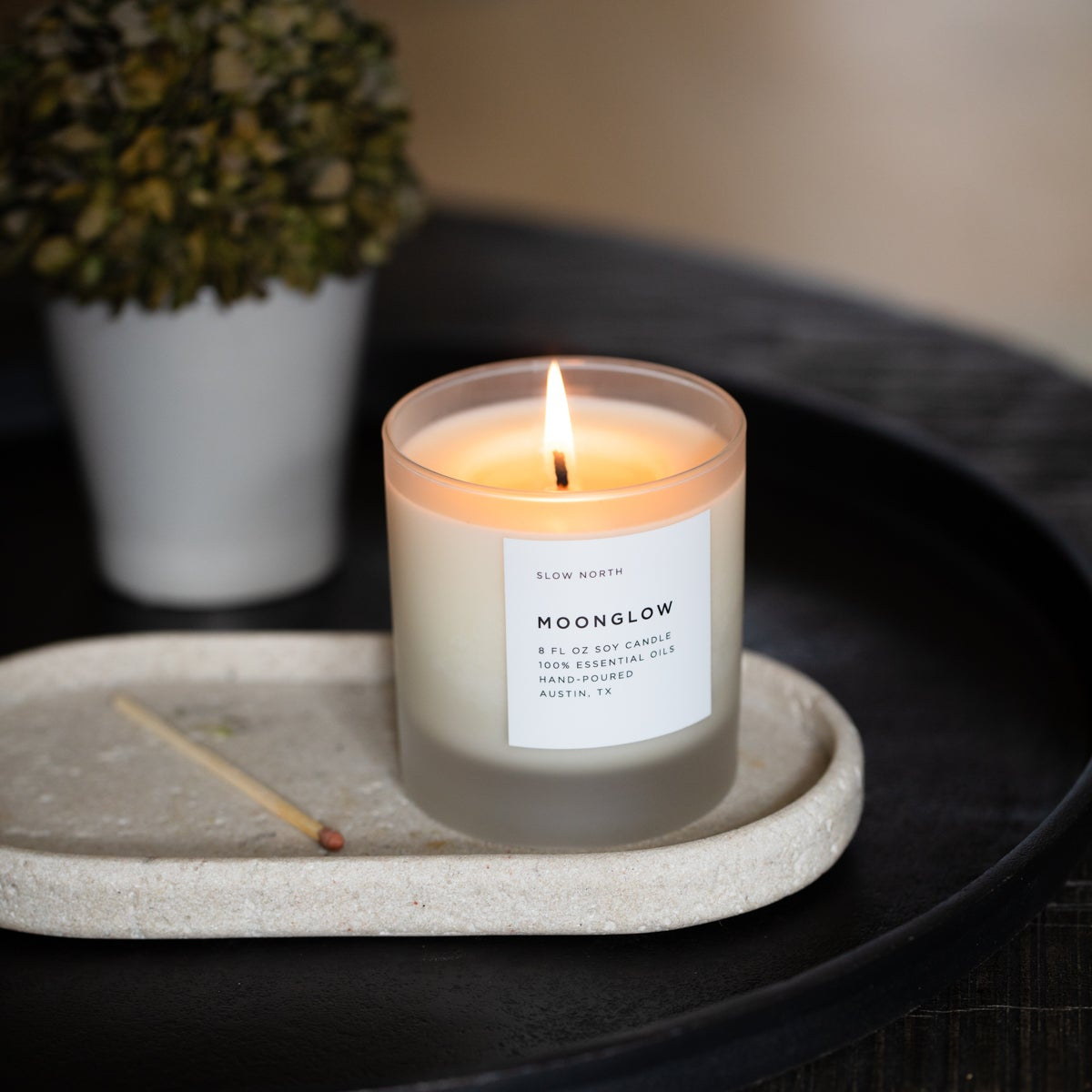 Frosted Moonglow Signature Candle by Slow North with patchouli, cinnamon, and black pepper scent in a frosted glass container