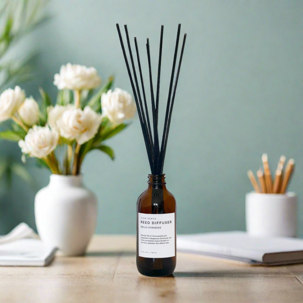 Slow North Hello Sunshine reed diffuser with a glass bottle and natural reed sticks on a neutral background.