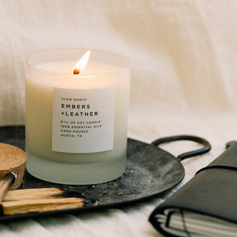 Frosted candle by Slow North with Embers + Leather scent featuring vetiver, cedar, and patchouli in an 8oz container.