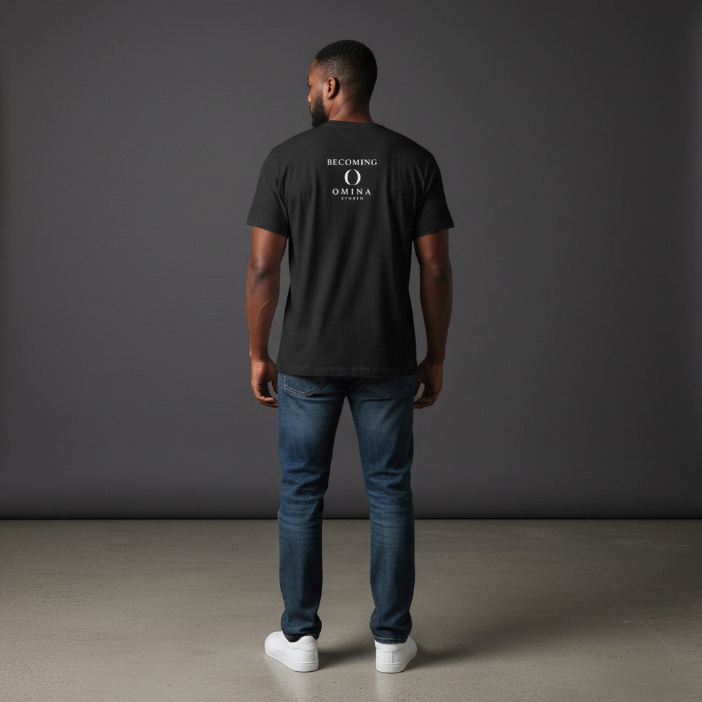 Man wearing a black Omina cotton t-shirt with a white Becoming logo on the back, paired with blue jeans.