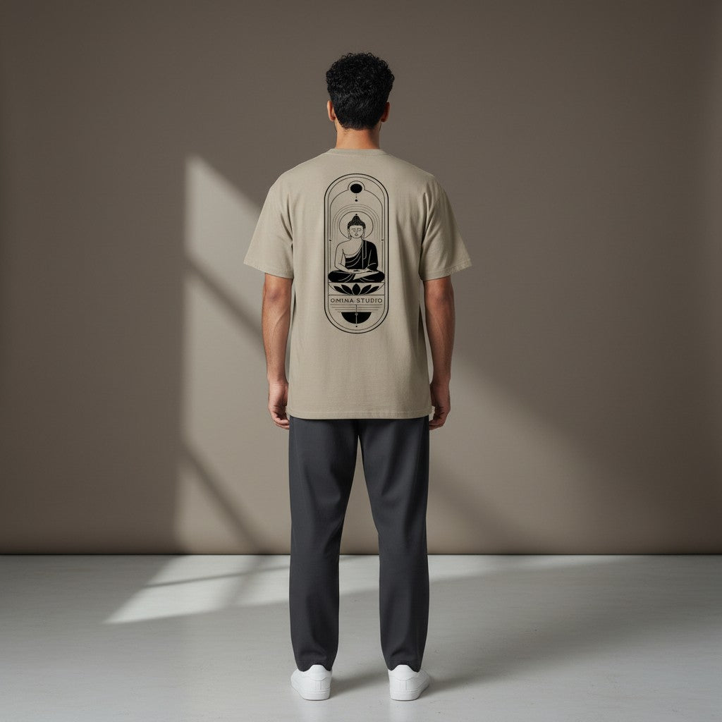 Man wearing a beige Omina heavyweight cotton t-shirt with a black Buddha graphic on the back, viewed from behind.