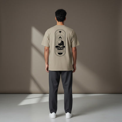 Man wearing a beige Omina heavyweight cotton t-shirt with a black Buddha graphic on the back, viewed from behind.