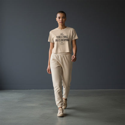 Model wearing Omina Essentials beige cropped tee with Future Is Female graphic and matching joggers in studio setting