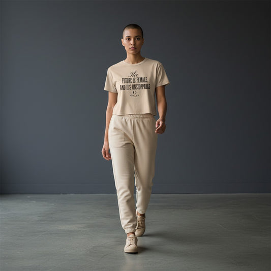 Model wearing Omina Essentials beige cropped tee with Future Is Female graphic and matching joggers in studio setting