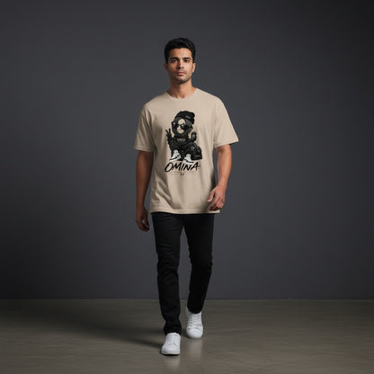 A man wearing an Omina beige short-sleeve cotton t-shirt with a graphic print, paired with black jeans and sneakers.