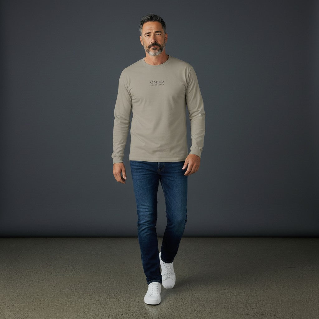 Man wearing a beige Omina premium cotton long sleeve t-shirt with drop shoulders and minimalist branding.