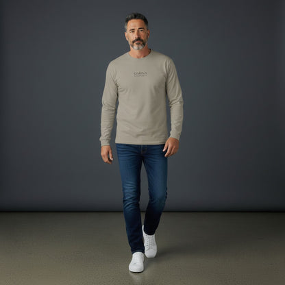 Man wearing a beige Omina premium cotton long sleeve t-shirt with drop shoulders and minimalist branding.