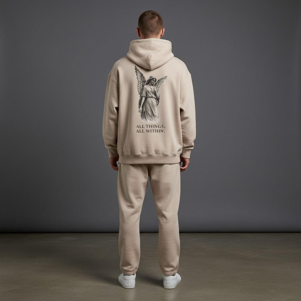 Back view of a man wearing an Omina beige oversized fleeced hoodie with an angel graphic and text print.