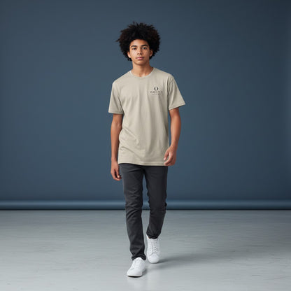A young man wearing an Omina beige performance t-shirt with a small logo, paired with dark jeans and white sneakers.