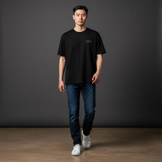 OMINA black premium cotton t-shirt with gold logo detail on chest, worn by a man with jeans.