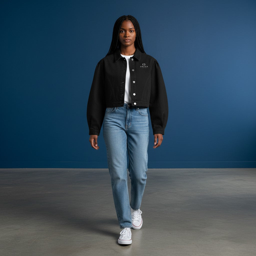 Model wearing an Omina black cropped denim jacket with button-front closure and structured collar over a white tee.