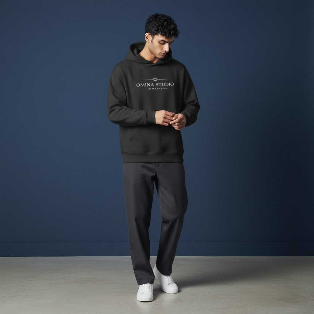 Omina Studio black heavyweight hoodie with raw edge detailing and front graphic logo. Relaxed fit, fleece interior.