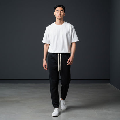 Omina black heavyweight cotton sweatpants with white drawstring and ribbed cuffs. Relaxed oversized fit.
