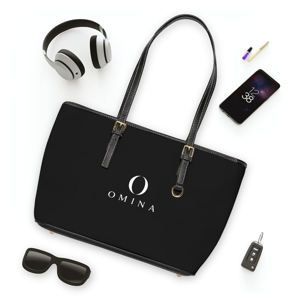 Omina black PU leather shoulder tote bag with gold hardware, adjustable straps, and centered white logo.