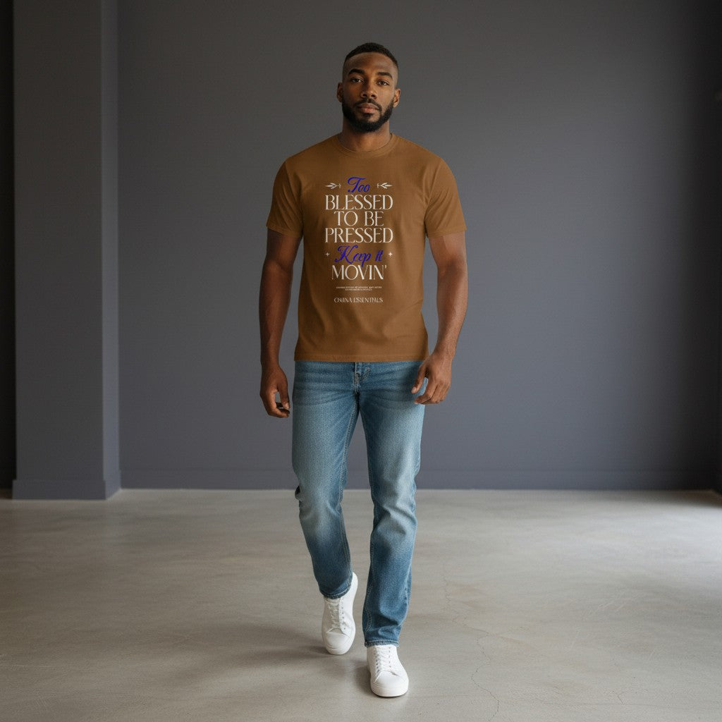 Man wearing Omina Blessed, Not Pressed brown heavyweight cotton t-shirt with graphic text, paired with blue jeans.