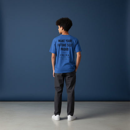 A boy wearing a blue Omina performance tee with Future Self Proud text on the back, standing against a blue wall.