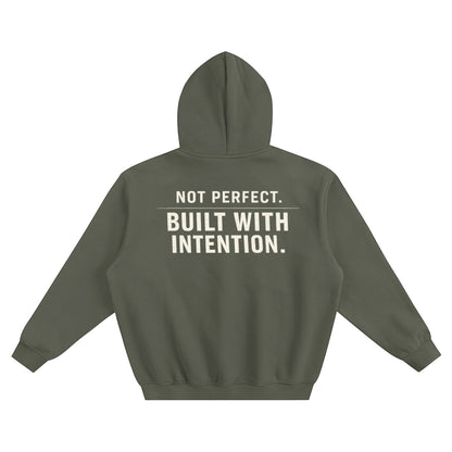 Omina olive green fleeced boxy hoodie with "NOT PERFECT. BUILT WITH INTENTION." graphic on back.