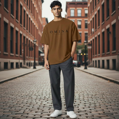 Omina Studio brown heavyweight cotton t-shirt with relaxed fit and dropped shoulders, worn by a man outdoors.