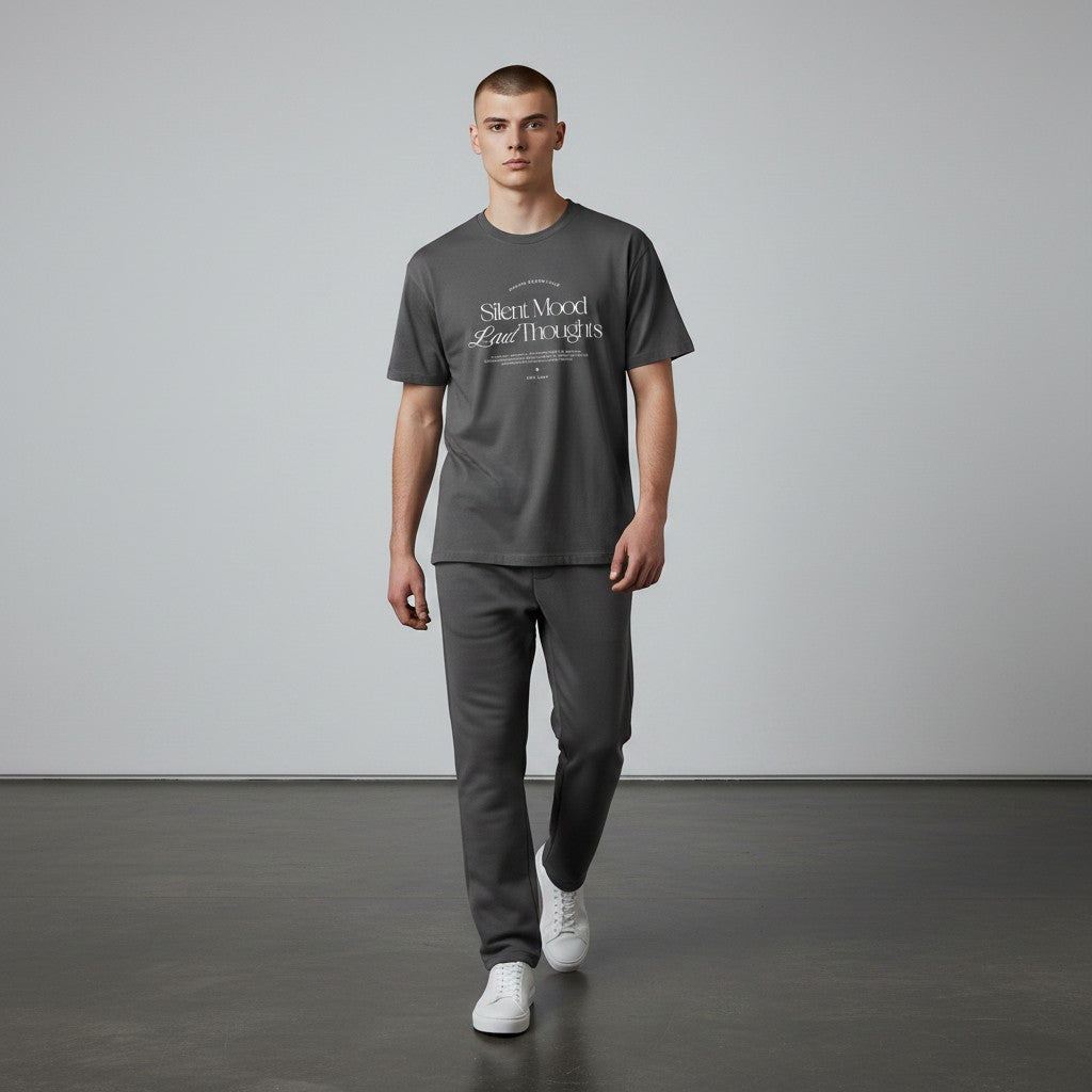 A model wearing an Omina charcoal grey cotton jersey t-shirt with Silent Mood graphic text, paired with matching pants.