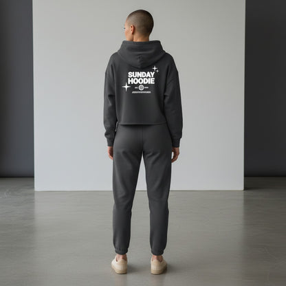 Omina charcoal grey cropped Sunday hoodie with back graphic, worn by a model with matching joggers in a studio.