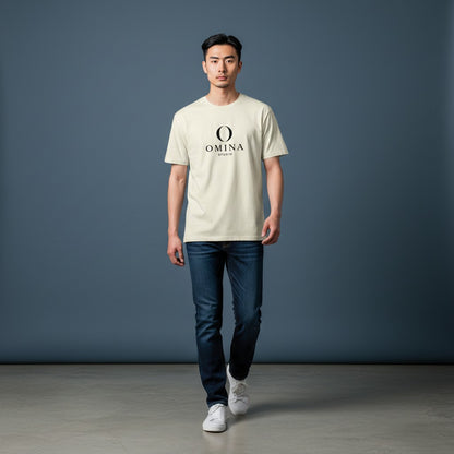 A man wearing an Omina cream-colored cotton crew neck T-shirt with a black O mascot logo, styled with dark blue jeans.