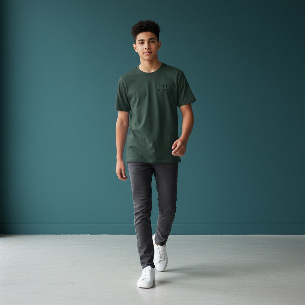 Young man wearing an Omina dark green performance tee with Future Self Proud branding, paired with grey jeans.