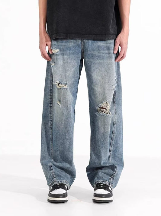 Omina blue wash distressed wide leg denim jeans on a male model.