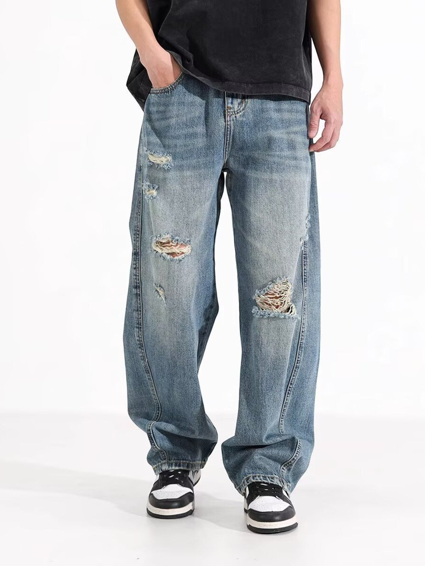 Omina blue wash distressed wide leg denim jeans on a male model.
