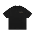 OMINA ESSENTIALS black heavyweight cotton t-shirt with oversized fit and drop shoulders. Minimal gold logo on chest.