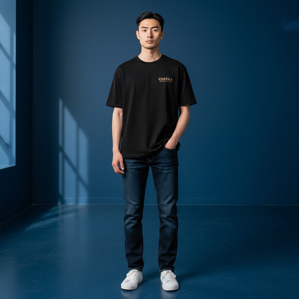 Omina Essentials black heavyweight cotton t-shirt with gold logo on chest, relaxed oversized fit, drop shoulders.