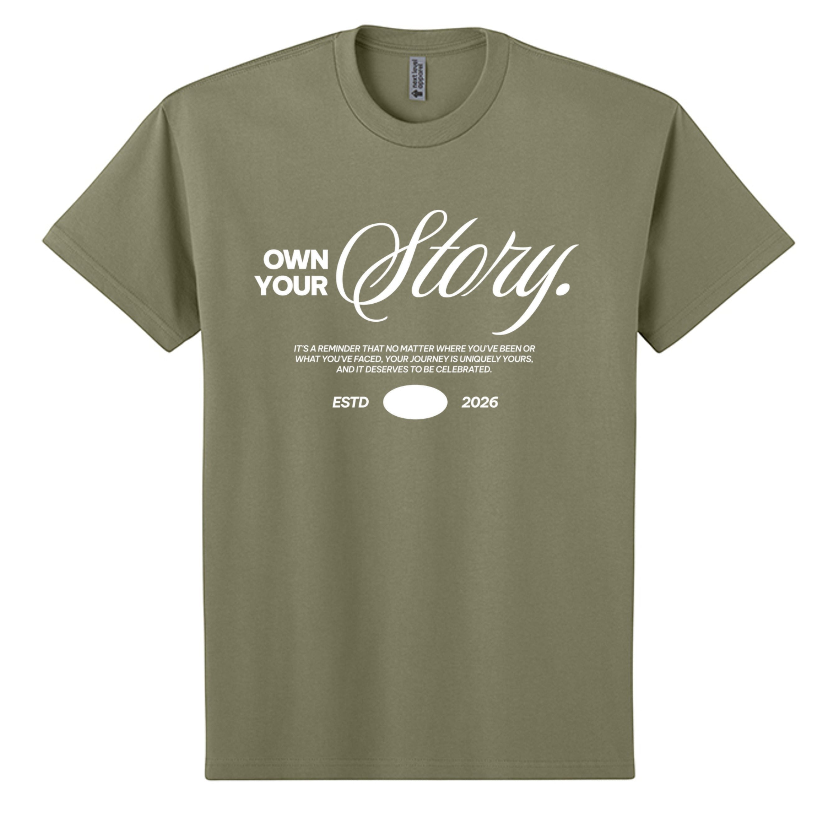 Omina Essentials olive green heavyweight cotton t-shirt with "Own Your Story" graphic print and ESTD 2026 detail.