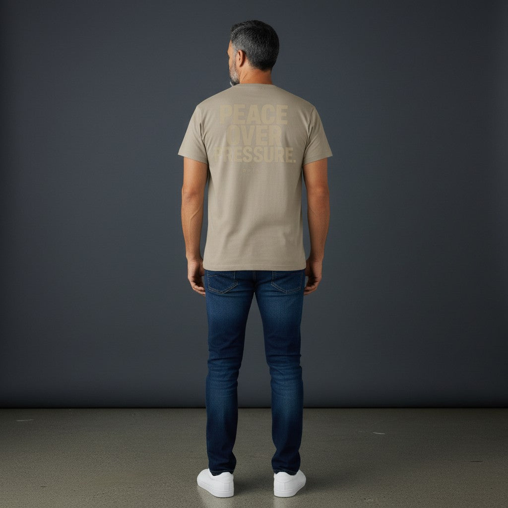 Omina Essentials oversized t-shirt in tan with large "PEACE OVER PRESSURE" graphic on back.