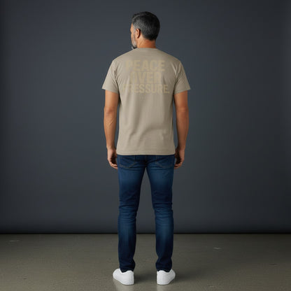 Omina Essentials oversized t-shirt in tan with large "PEACE OVER PRESSURE" graphic on back.