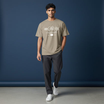 Omina Essentials oversized taupe heavyweight cotton t-shirt with "Own Your Story" graphic print.