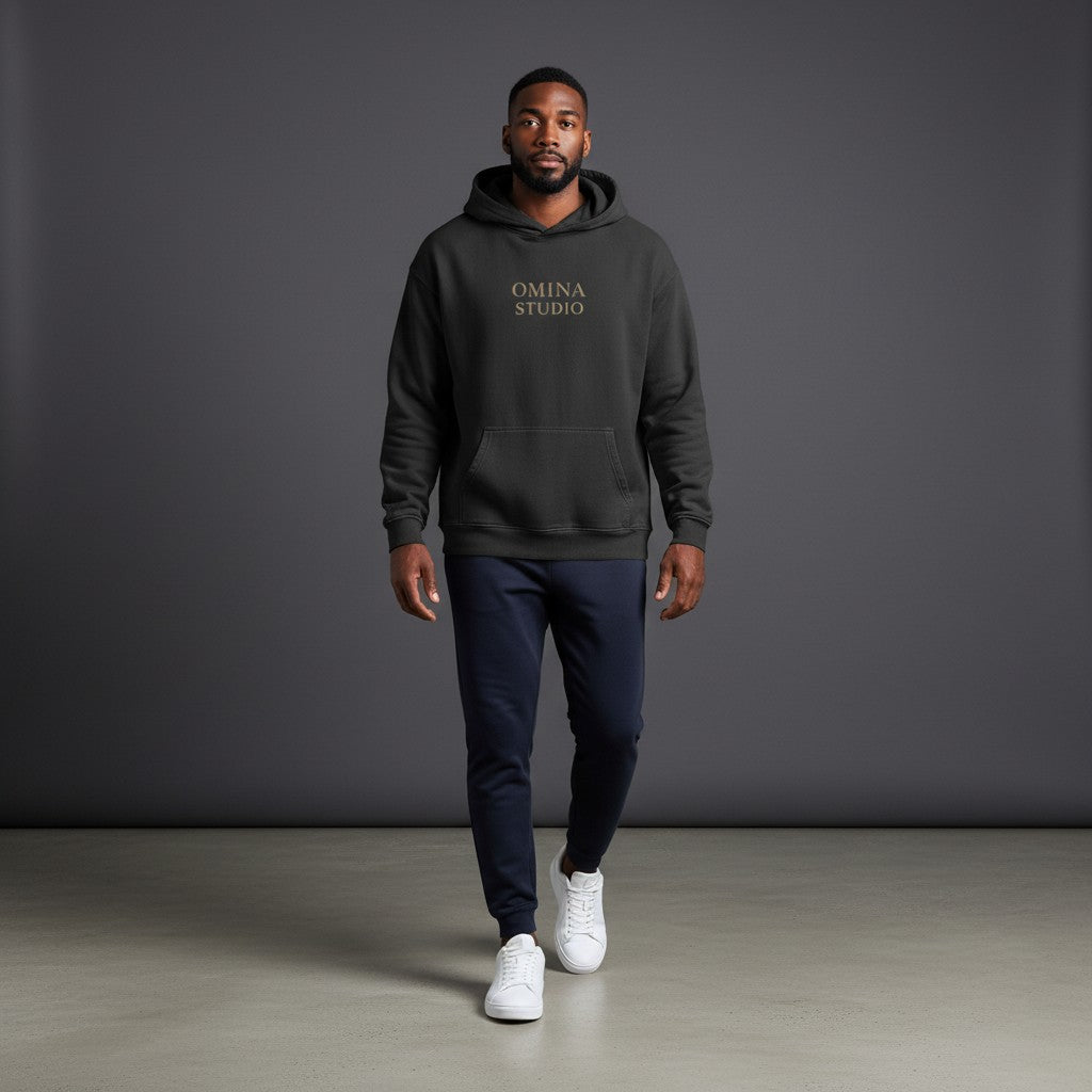 OMINA STUDIO black oversized pullover hoodie with minimalist chest logo and large "FAITH OVER FEAR" graphic on back.