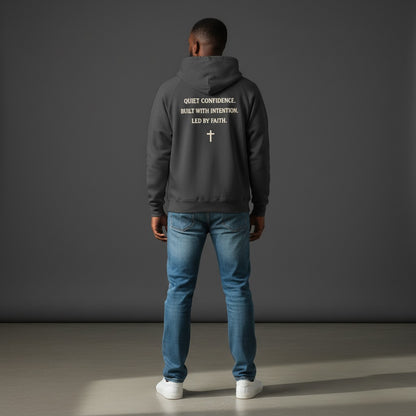 Omina Studio dark grey heavyweight cotton pullover hoodie with "Quiet Confidence. Built With Intention. Led By Faith." text and a cross graphic.