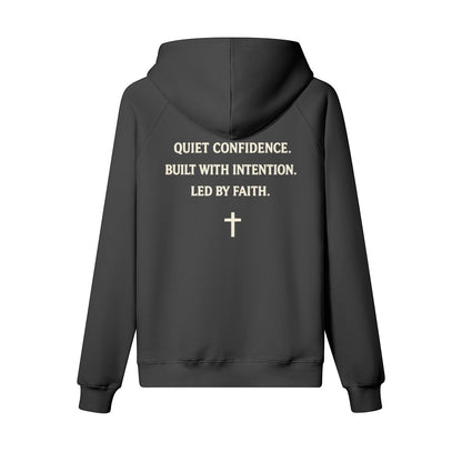 Omina Studio dark grey heavyweight cotton pullover hoodie with "Quiet Confidence. Built With Intention. Led By Faith." text and a cross graphic.