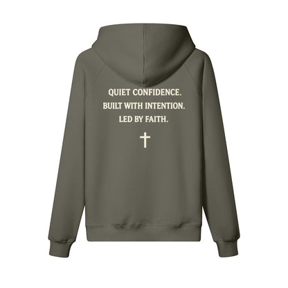 Omina Studio olive green heavyweight cotton pullover hoodie with "Quiet Confidence. Built With Intention. Led By Faith." text and a cross graphic.