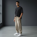Omina Studio light brown washed cotton sweatpants with relaxed fit and vertical FORM/IDENTITY logo on the left leg.